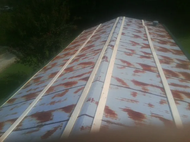 Rusted metal roof panels with new wood purlins before replacement — Storm Damage Roof Repair in Lowpoint by Roofing Brothers