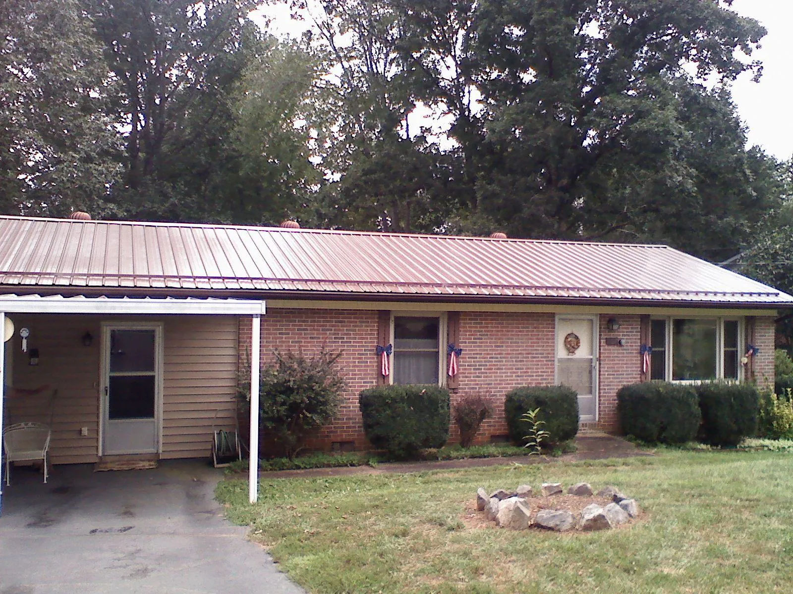 Bronze metal roof and carport on a brick ranch home — Roof Repair work by our crew in Lowpoint